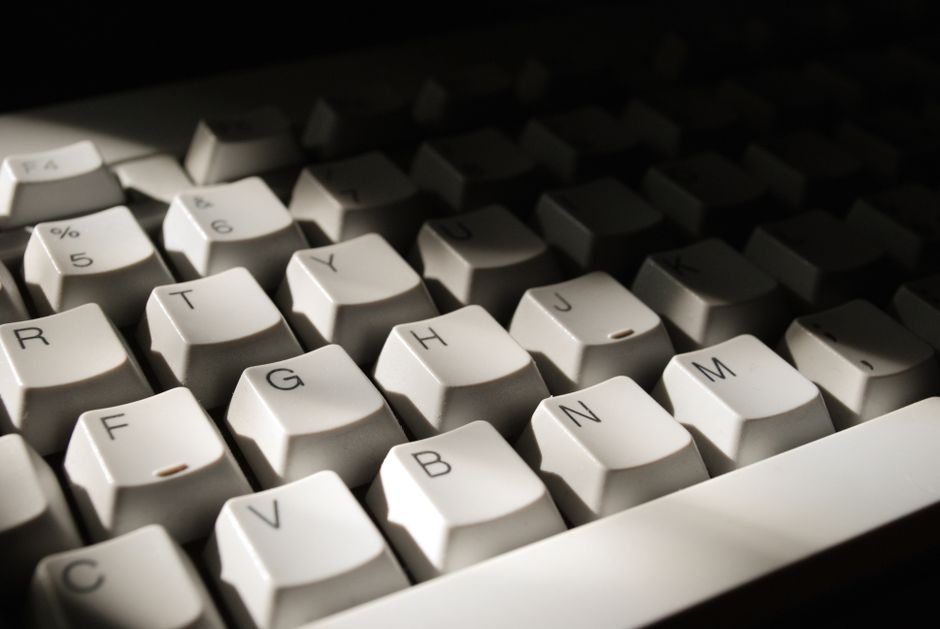 Detailed close-up of computer keyboard keys with dramatic lighting, highlighting letters and numbers.